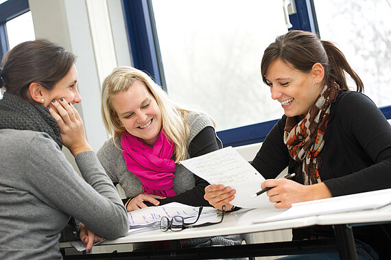 Eine Gruppe von Studentinnen bespricht sich in der Gruppe
