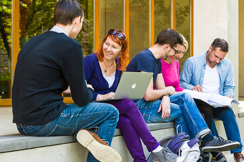 Studierende sitzen auf dem Campus der HTW Dresden
